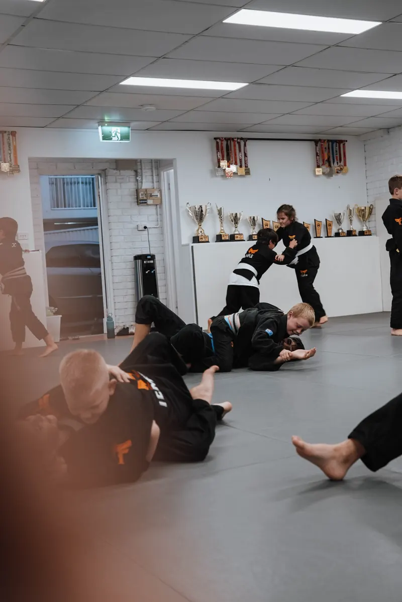 Kids drilling guard work on the mats at Temple BJJ